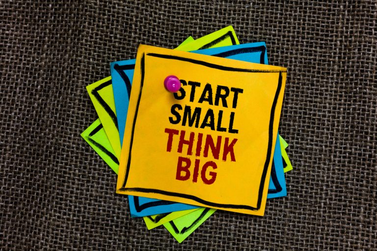 Text sign showing Start Small Think Big. Conceptual photo Initiate with few things have something great in mind Black bordered different color sticky note stick together with pin on jute sack